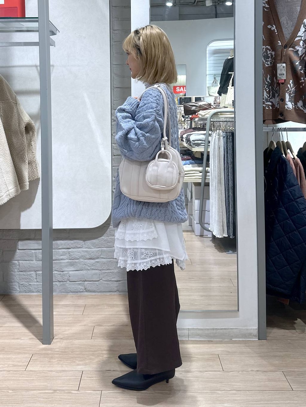 ブラウン系のその他パンツ、ホワイト系のスカート、ブルー系のニット/セーターを着用したレディースの秋コーディネートの3枚目の写真