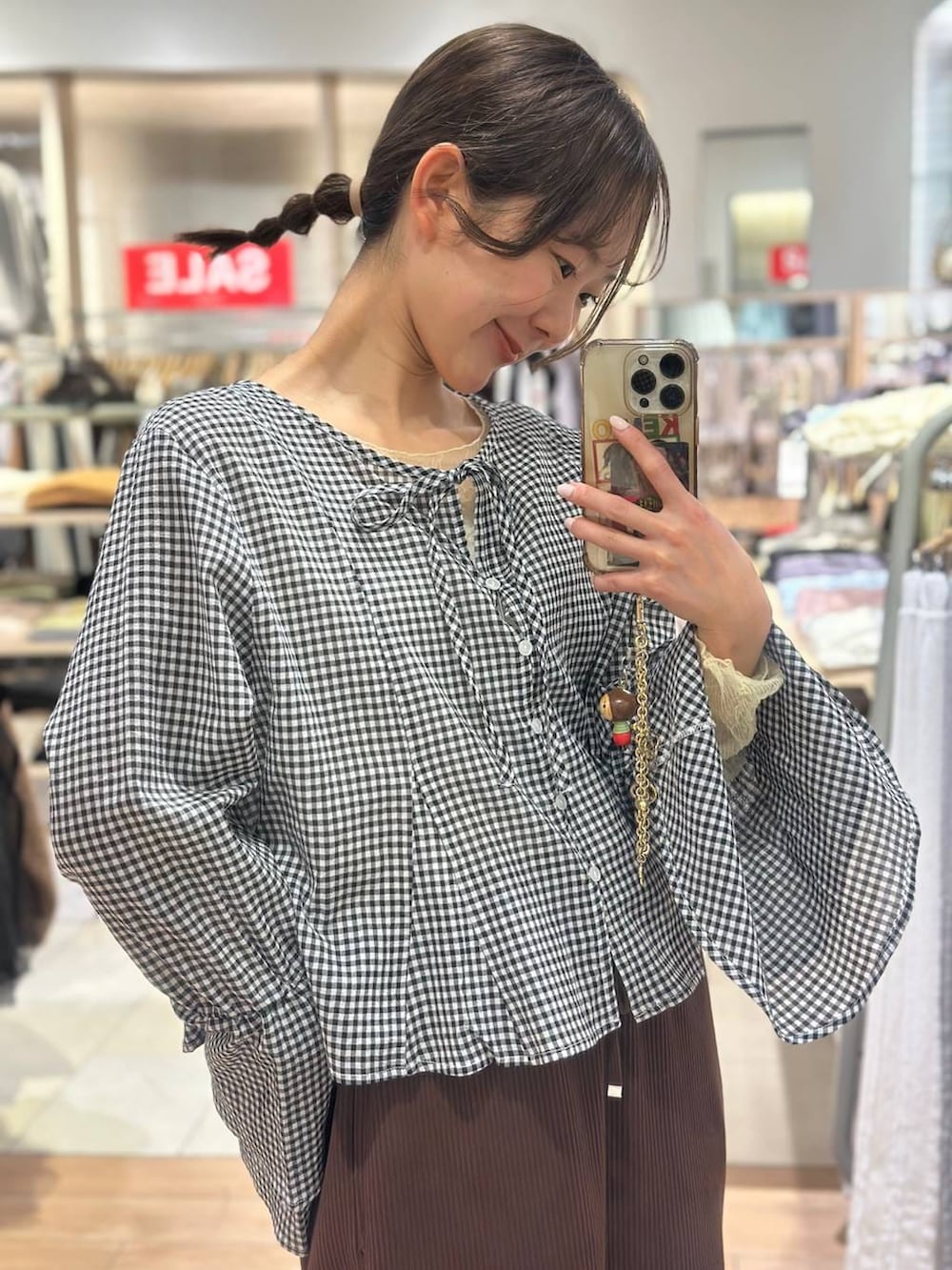 ブラウン系のスカート、ブラック系のローファー、ブラック系のシャツ/ブラウスを着用したレディースの春コーディネートの6枚目の写真