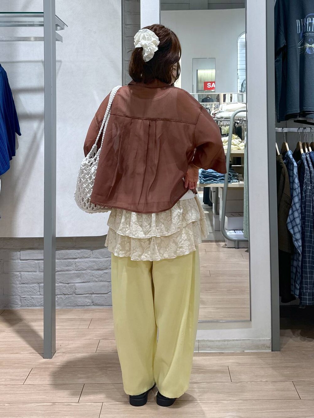 ホワイト系のサンダル、ホワイト系のトートバッグ、ブラウン系のシャツ/ブラウスを着用したレディースの夏コーディネートの4枚目の写真