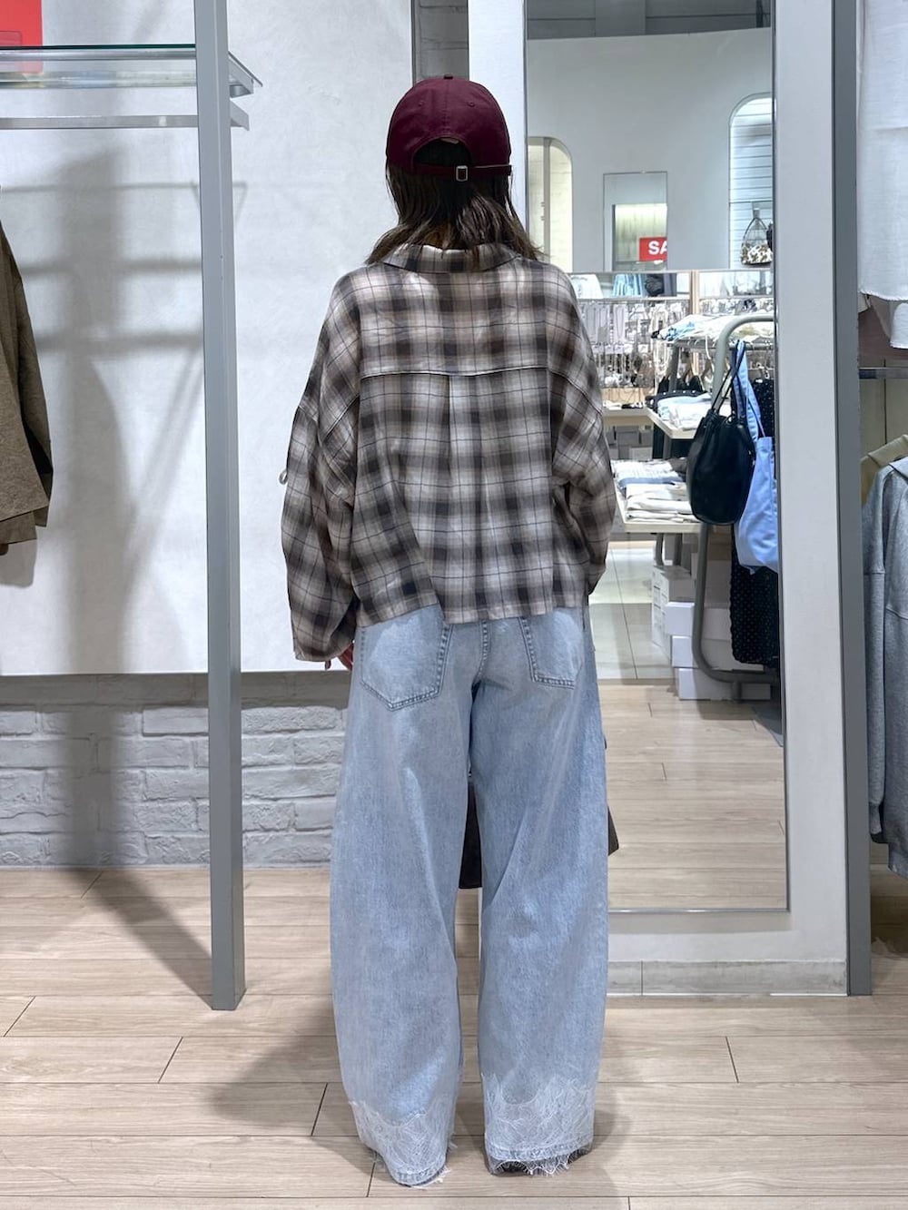 ホワイト系のTシャツ/カットソー、ブルー系のデニムパンツ、ブラウン系のショルダーバッグを着用したレディースの春コーディネートの6枚目の写真