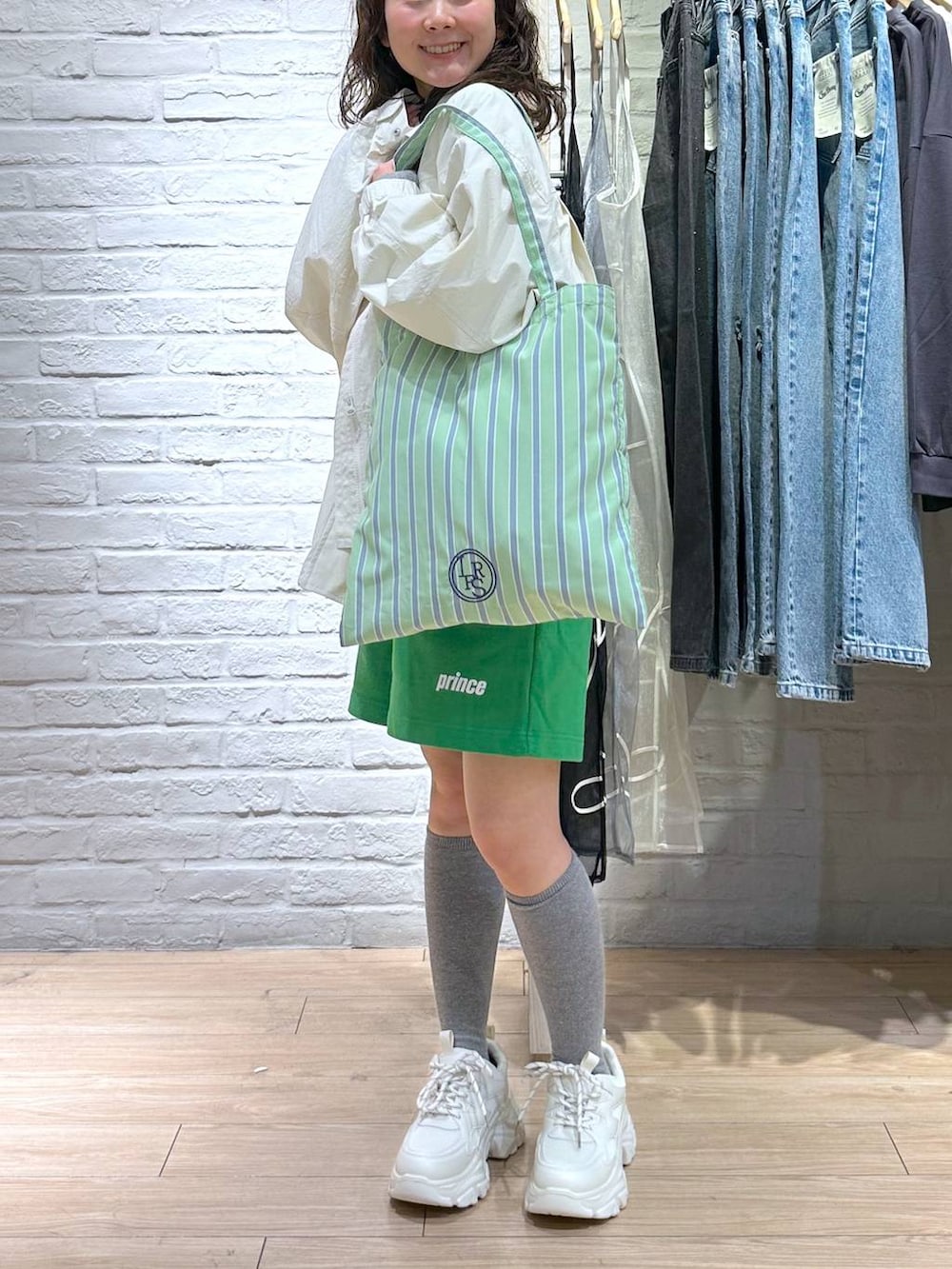 その他のトートバッグ、ブラック系のニット/セーター、ホワイト系のスニーカーを着用したレディースの冬コーディネートの2枚目の写真