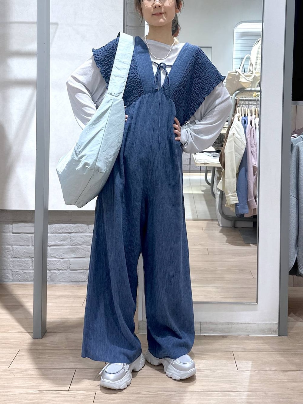 ブルー系のサロペット/オーバーオール、グレー系のTシャツ/カットソー、ブルー系のショルダーバッグを着用したレディースの春コーディネートの2枚目の写真