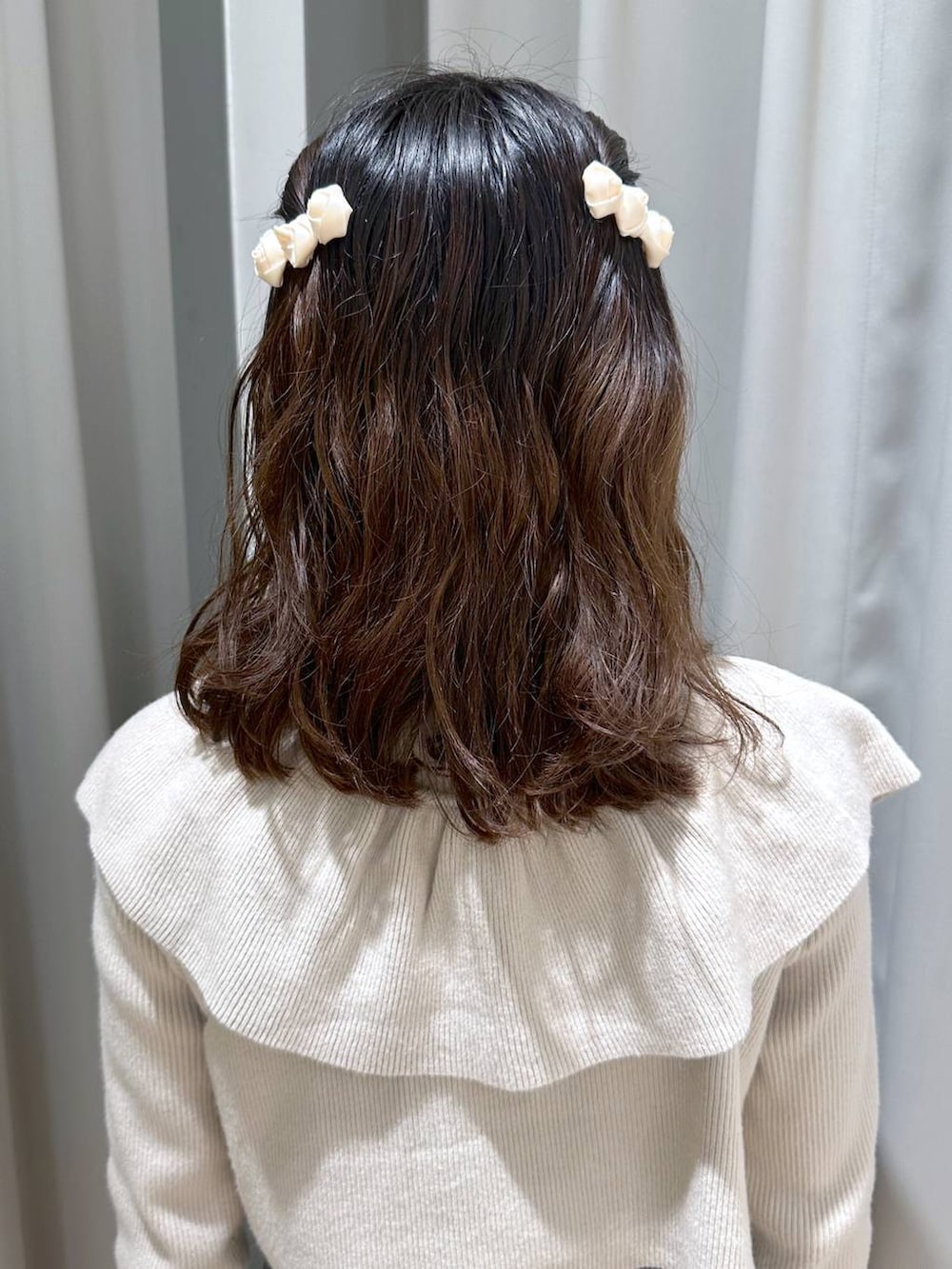 ベージュ系のニット/セーター、ブラウン系のネックレス、ホワイト系のバレッタ/ヘアクリップを着用したレディースの冬コーディネートの4枚目の写真