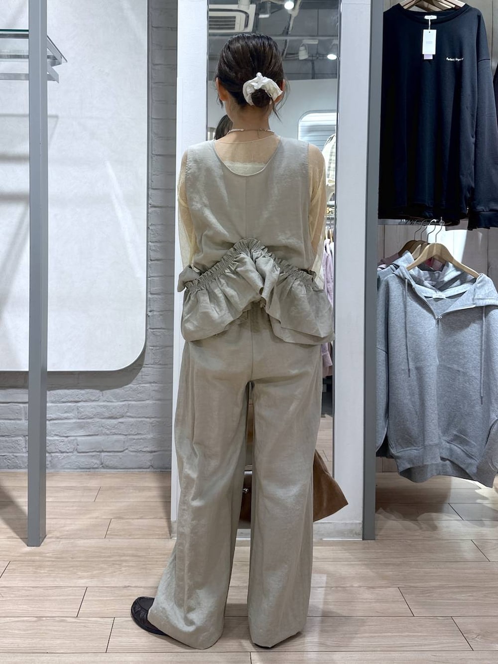 ゴールド系のタンクトップ、ブラック系のローファー、ブラウン系のショルダーバッグを着用したレディースの春コーディネートの7枚目の写真