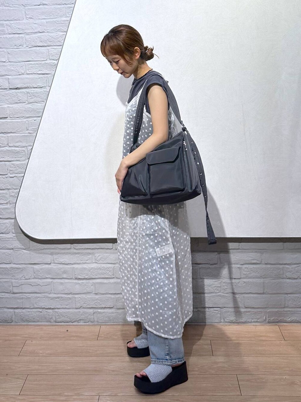 シルバー系のサンダル、ブルー系のデニムパンツ、ホワイト系のワンピースを着用したレディースの夏コーディネートの5枚目の写真