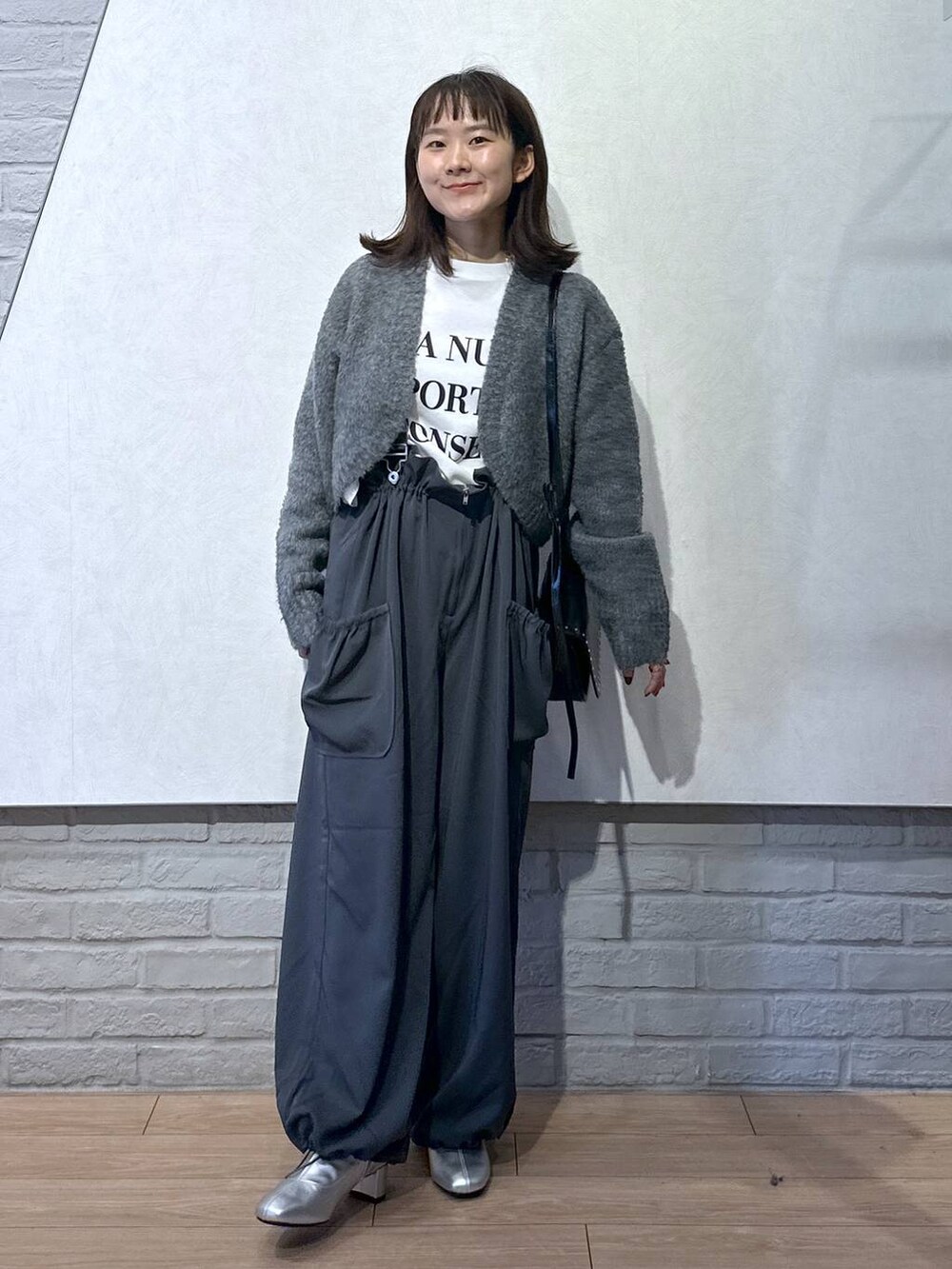 グレー系のワンピース、ブラック系のショルダーバッグ、ホワイト系のTシャツ/カットソーを着用したレディースの秋コーディネートの2枚目の写真