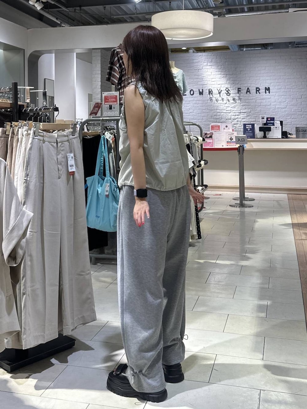 ホワイト系のTシャツ/カットソー、グレー系のスウェットパンツ、ブラック系のサンダルを着用したレディースの夏コーディネートの4枚目の写真
