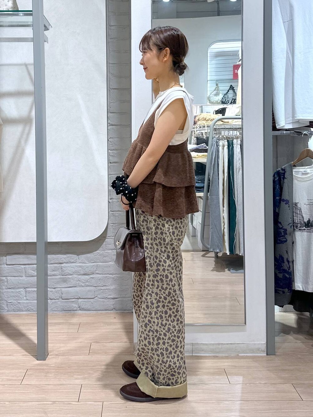 ブラウン系のスニーカー、その他のデニムパンツ、ブラウン系のボストンバッグを着用したレディースの秋コーディネートの3枚目の写真