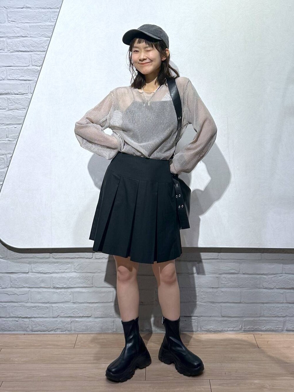 ブラック系のスカート、ブラック系のボディバッグ/ウエストポーチ、ホワイト系のシャツ/ブラウスを着用したレディースの夏コーディネートの4枚目の写真