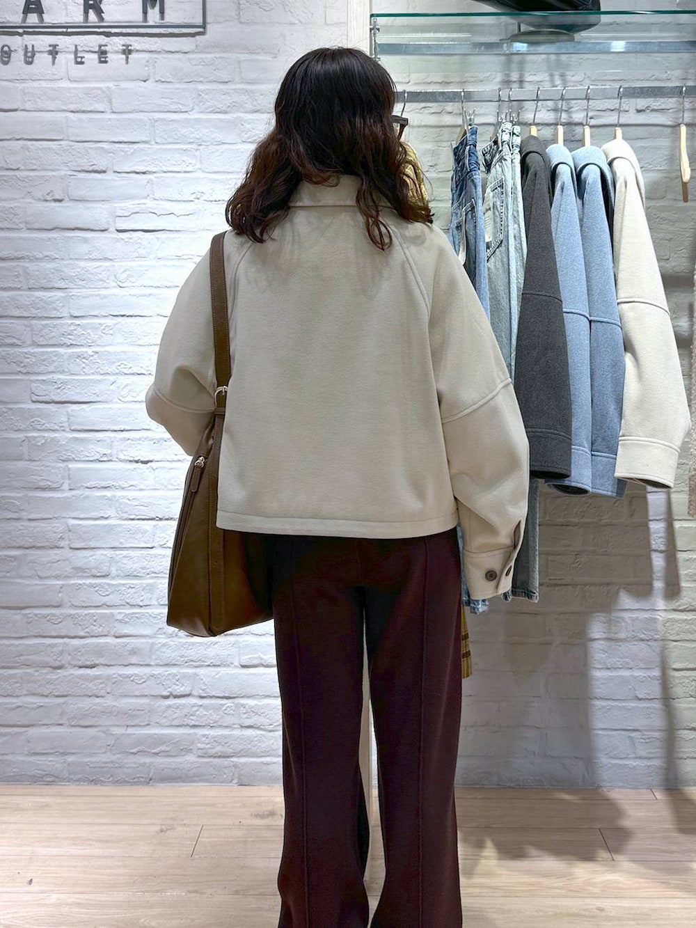 ホワイト系のニット/セーター、ベージュ系のスニーカー、ブラウン系のショルダーバッグを着用したレディースの冬コーディネートの5枚目の写真