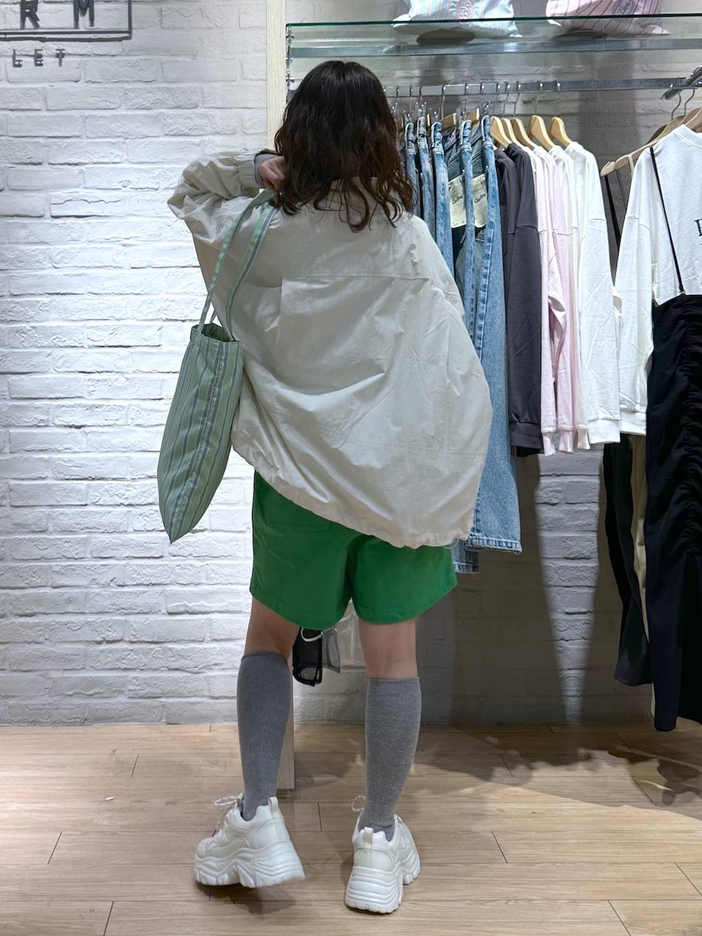 その他のトートバッグ、ブラック系のニット/セーター、ホワイト系のスニーカーを着用したレディースの冬コーディネートの4枚目の写真