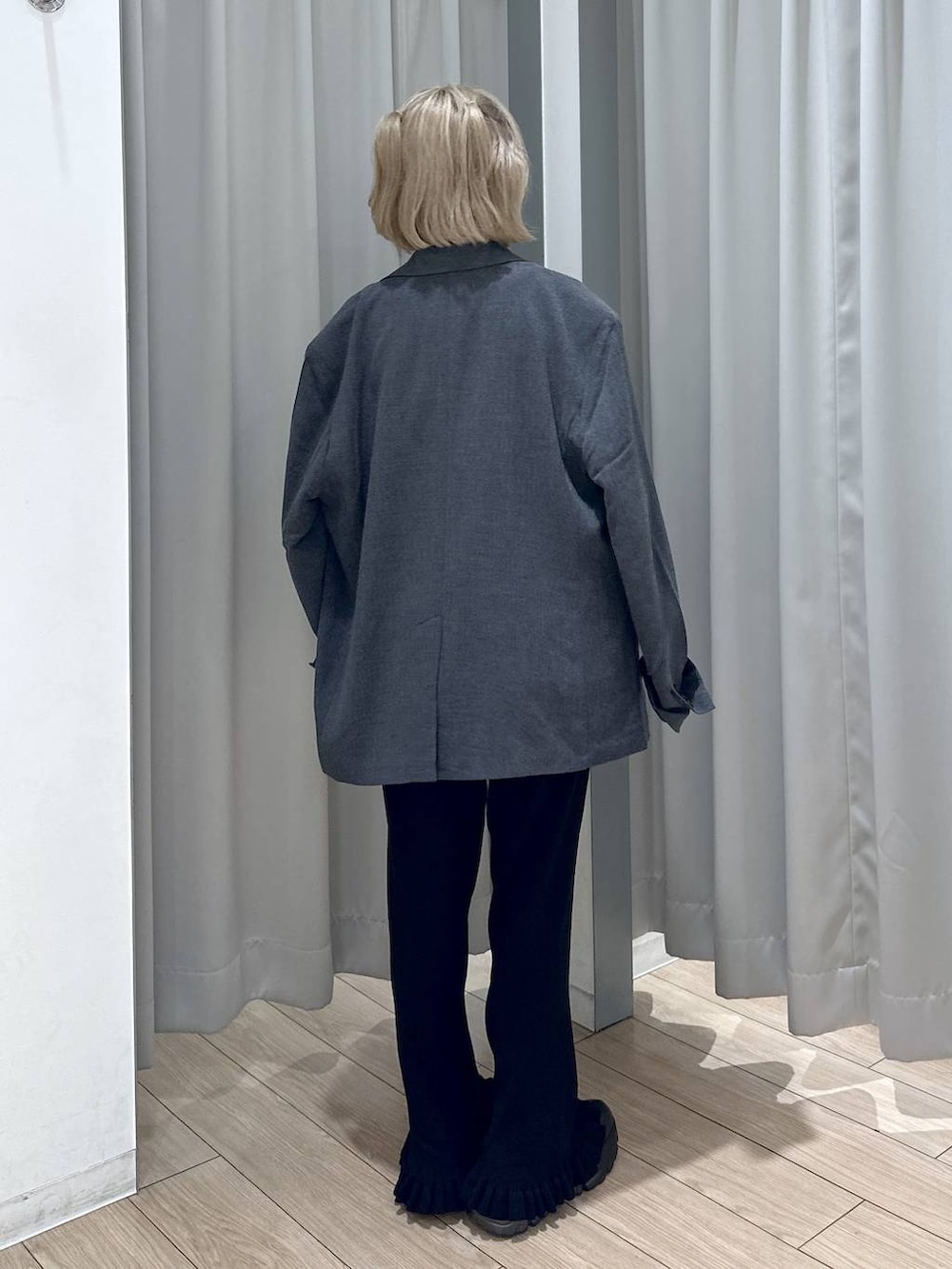 ブラック系のブーツ、グレー系のテーラードジャケット、ブラック系のその他パンツを着用したレディースの秋コーディネートの4枚目の写真