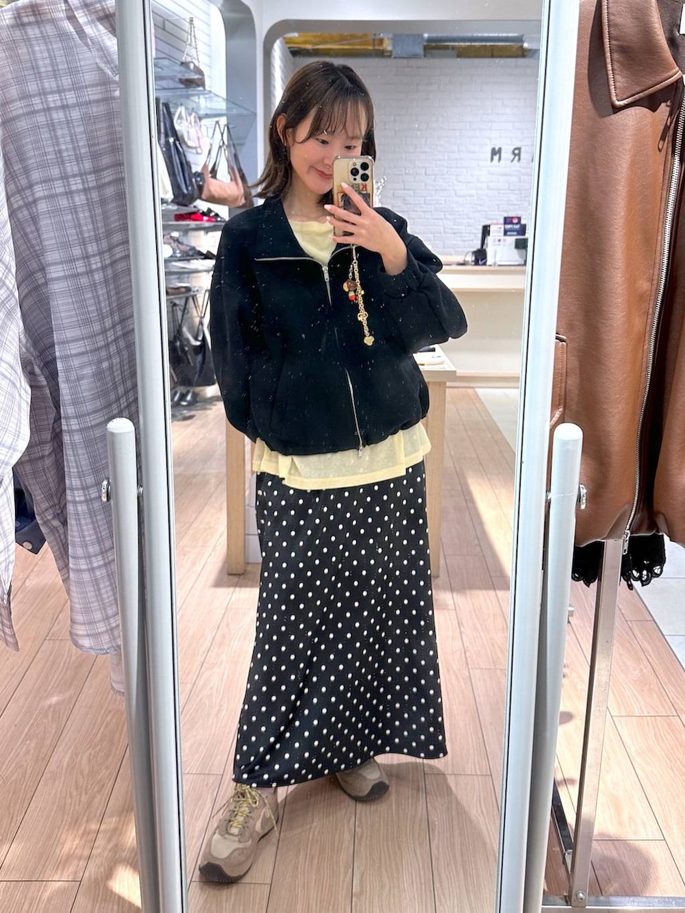 ブラック系のスカート、イエロー系のTシャツ/カットソー、ブラック系のスウェットを着用したレディースの春コーディネートの4枚目の写真