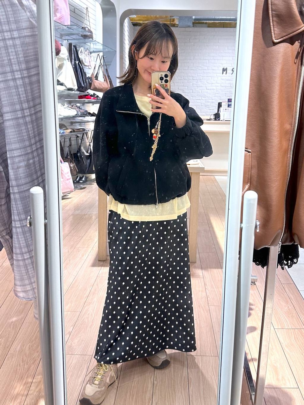 ブラック系のスカート、イエロー系のTシャツ/カットソー、ブラック系のスウェットを着用したレディースの春コーディネートの2枚目の写真