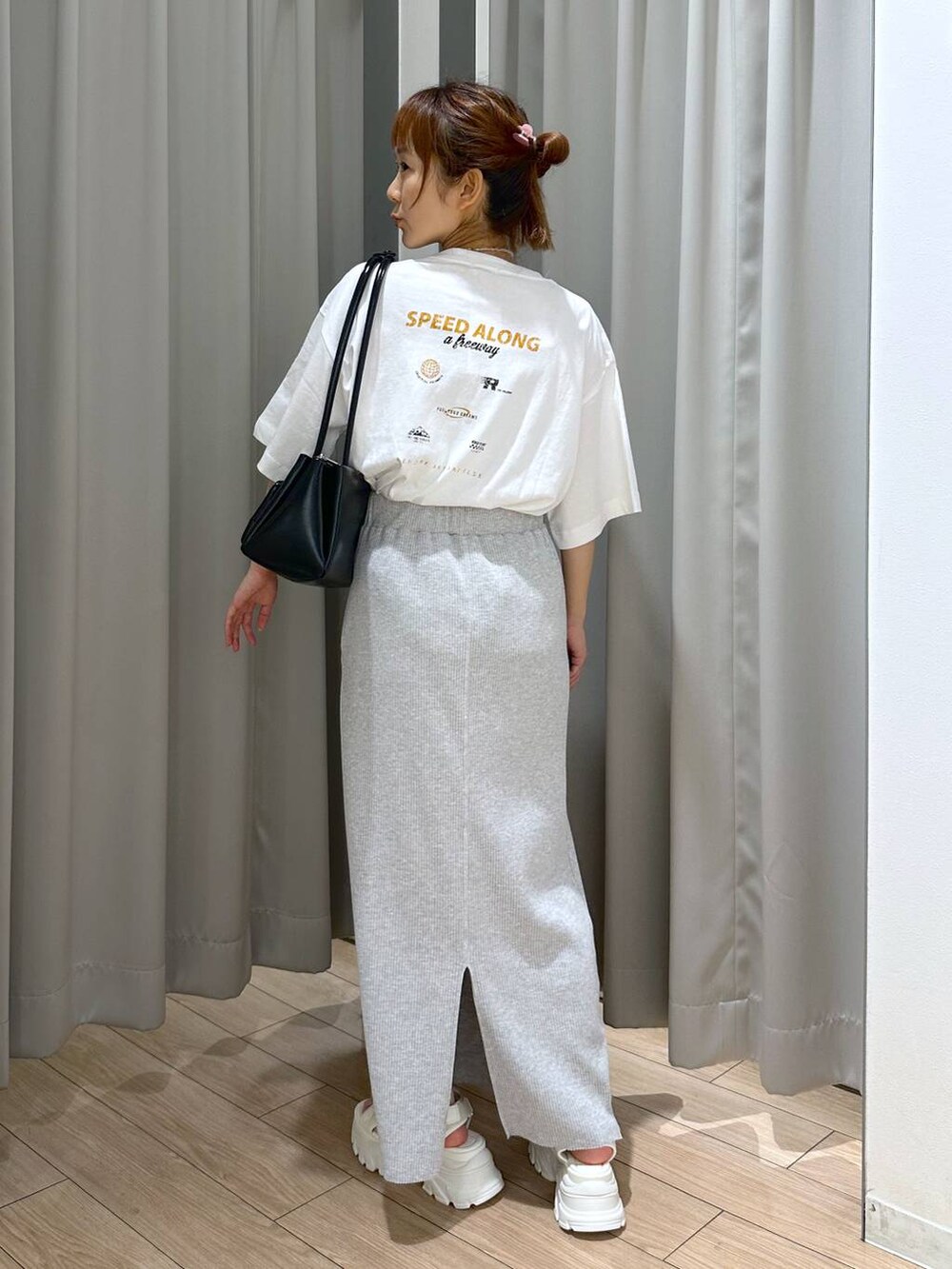 グレー系のスカート、ホワイト系のサンダル、ホワイト系のTシャツ/カットソーを着用したレディースの夏コーディネートの3枚目の写真