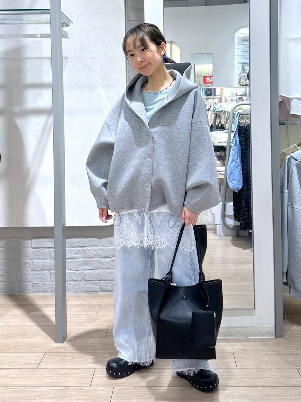 グリーン系のTシャツ/カットソー、ブルー系のデニムパンツ、ブラック系のサンダルを着用したレディースの春コーディネートの4枚目の写真