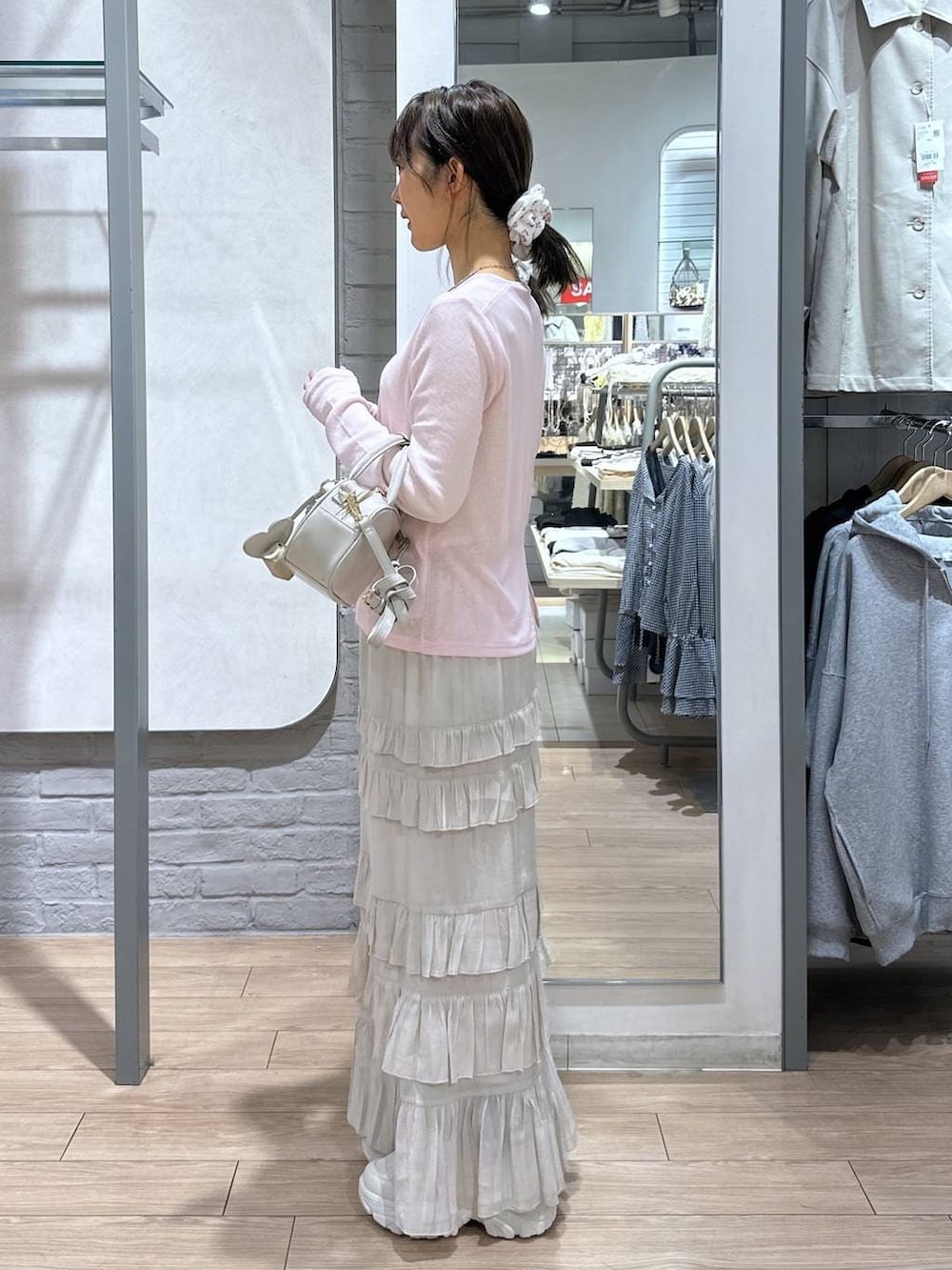 ホワイト系のボストンバッグ、ピンク系のTシャツ/カットソー、ホワイト系のスカートを着用したレディースの春コーディネートの3枚目の写真