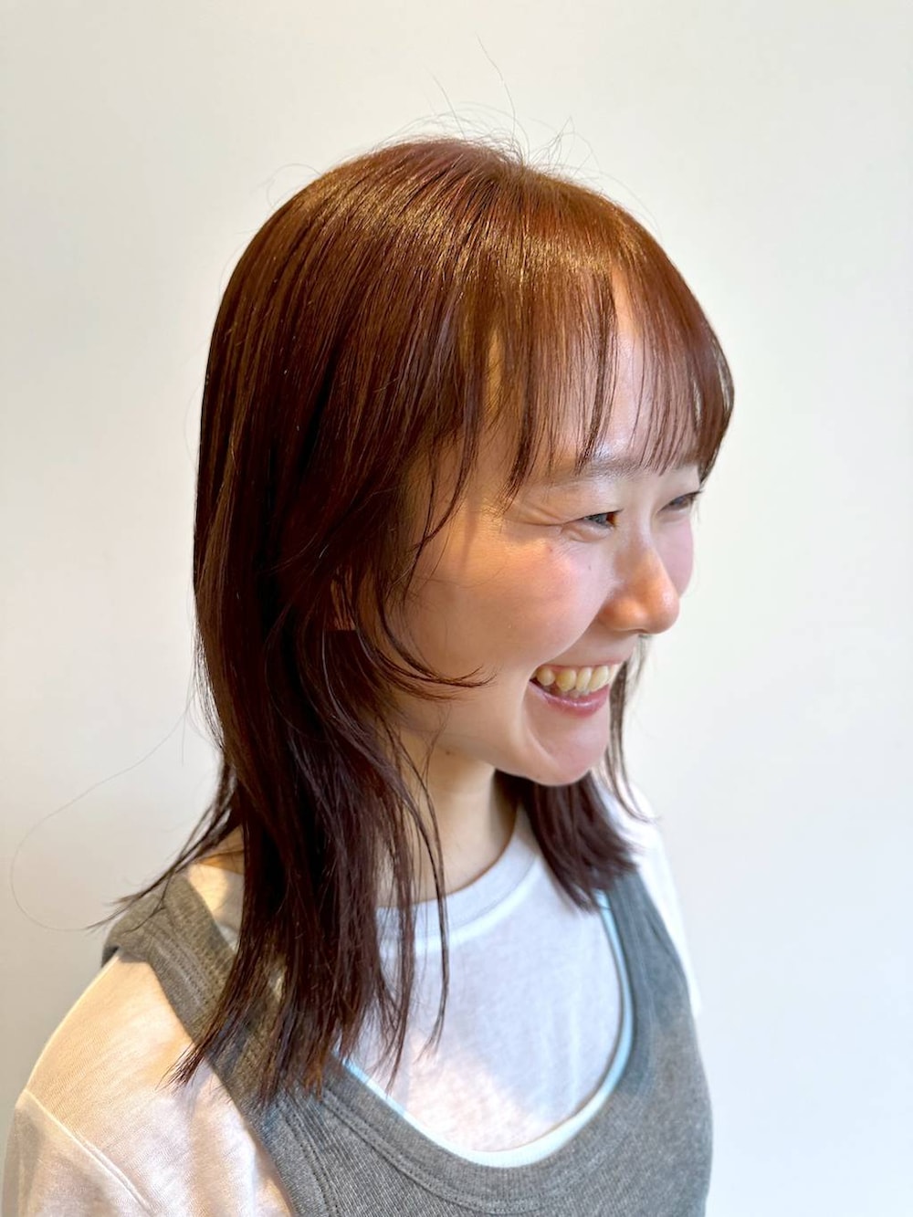 グレー系のタンクトップ、ホワイト系のTシャツ/カットソー、イエロー系のベルトを着用したレディースの夏コーディネートの3枚目の写真