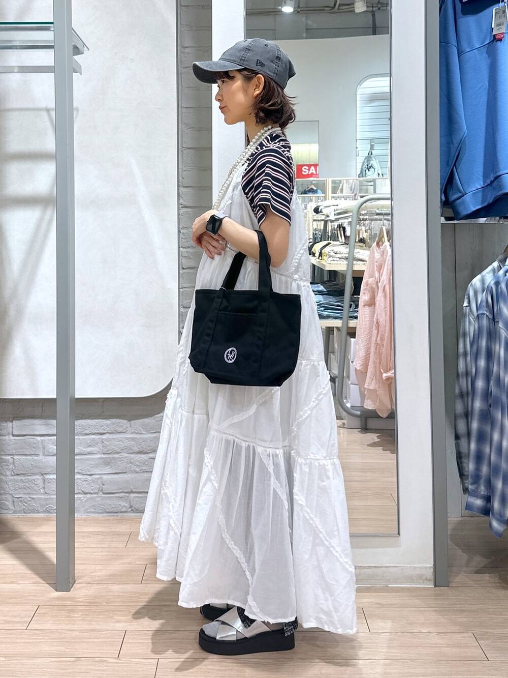 ブルー系のTシャツ/カットソー、ブラック系のデニムパンツ、ブラック系のショルダーバッグを着用したレディースの春コーディネートの2枚目の写真
