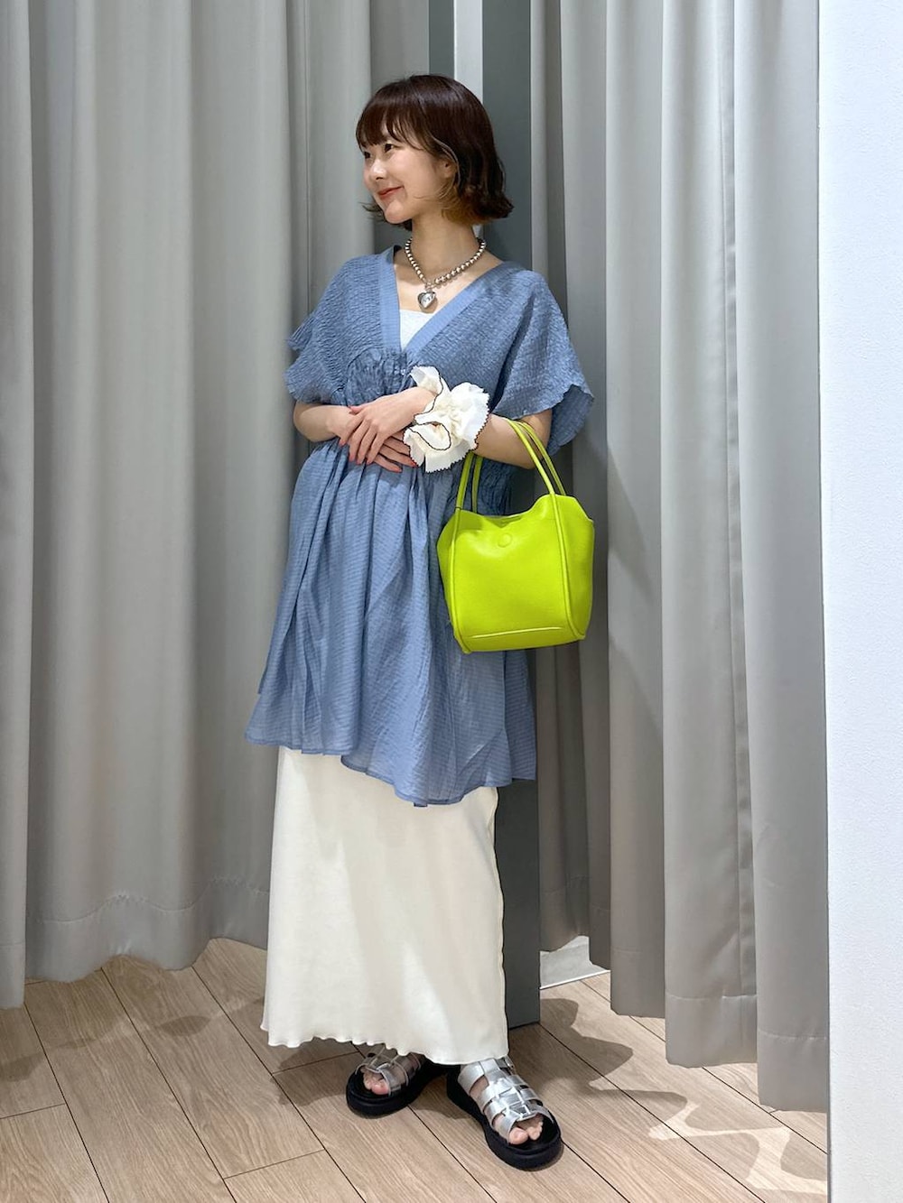 シルバー系のサンダル、シルバー系のタンクトップ、ホワイト系のスカートを着用したレディースの夏コーディネートの2枚目の写真