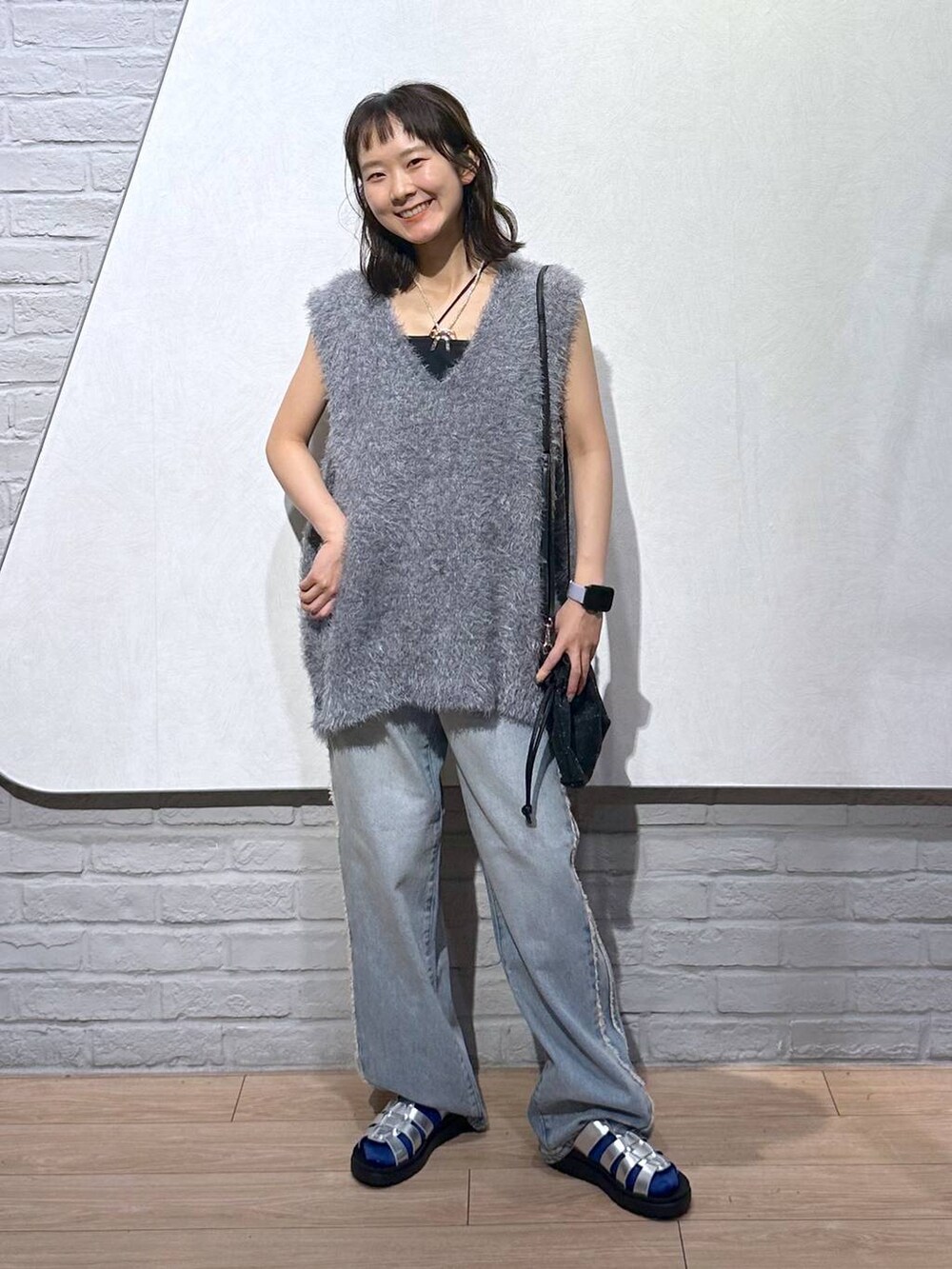 ブルー系のデニムパンツ、シルバー系のスニーカー、ブラック系のキャミソールを着用したレディースの夏コーディネートの2枚目の写真