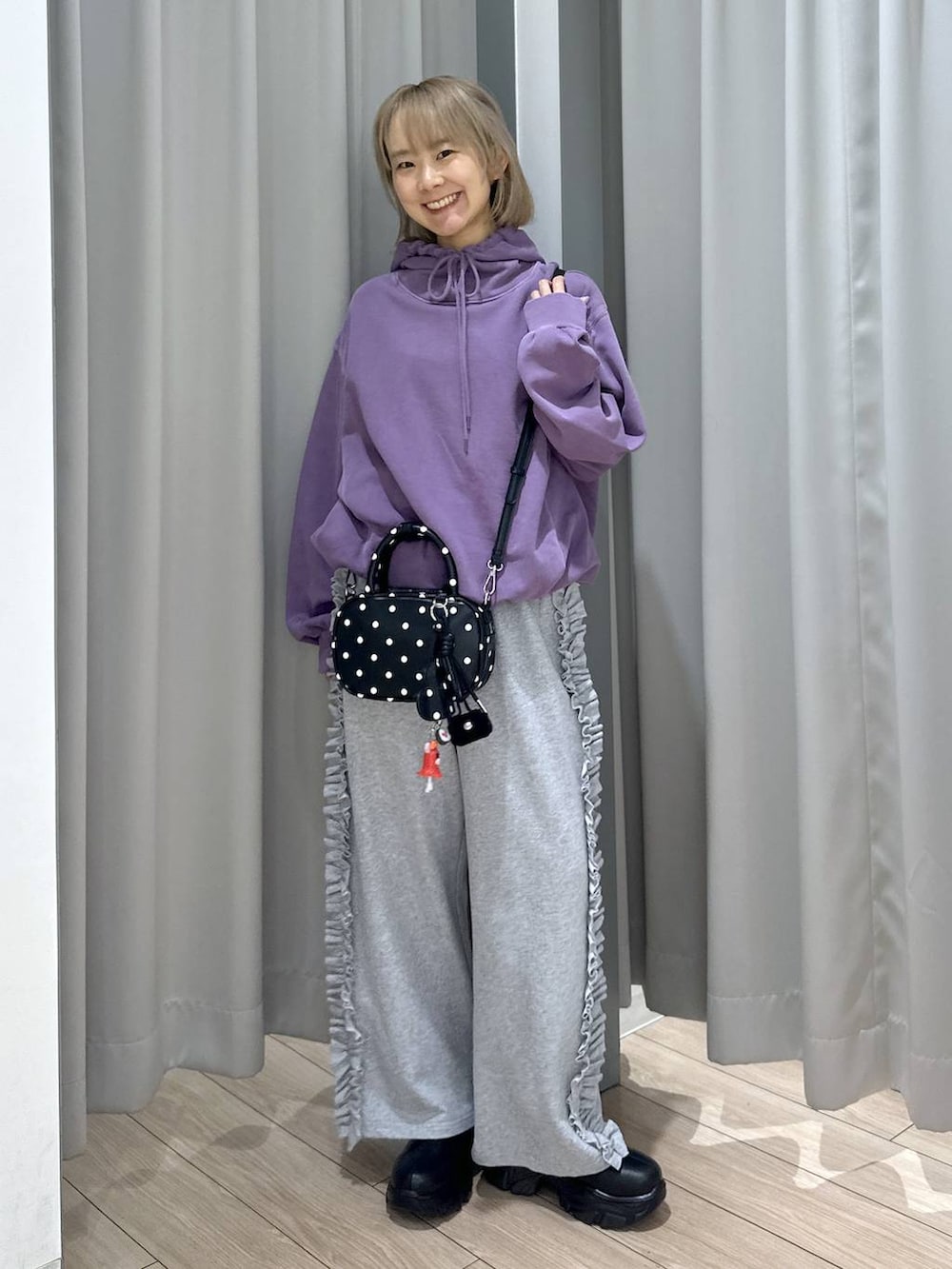 ブラック系のブーツ、パープル系のパーカー、その他のボストンバッグを着用したレディースの秋コーディネートの4枚目の写真