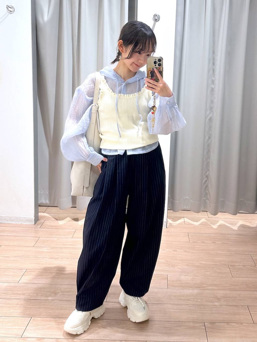 ホワイト系のショルダーバッグ、ブルー系のその他パンツ、ホワイト系のスニーカーを着用したレディースの春コーディネートの2枚目の写真