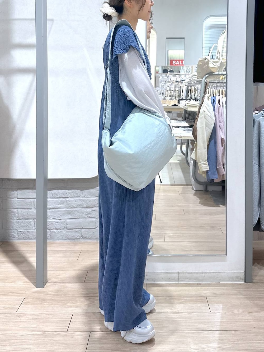 ブルー系のサロペット/オーバーオール、グレー系のTシャツ/カットソー、ブルー系のショルダーバッグを着用したレディースの春コーディネートの4枚目の写真