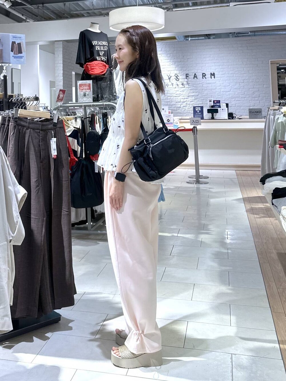 ピンク系のスウェットパンツ、ホワイト系のサンダル、ホワイト系のシャツ/ブラウスを着用したレディースの夏コーディネートの2枚目の写真