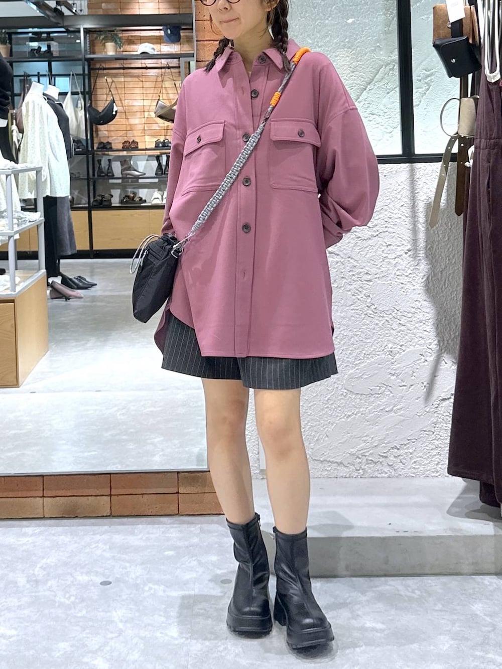 ブラック系のブーツ、ブラック系のショルダーバッグ、ホワイト系のTシャツ/カットソーを着用したレディースの秋コーディネートの2枚目の写真