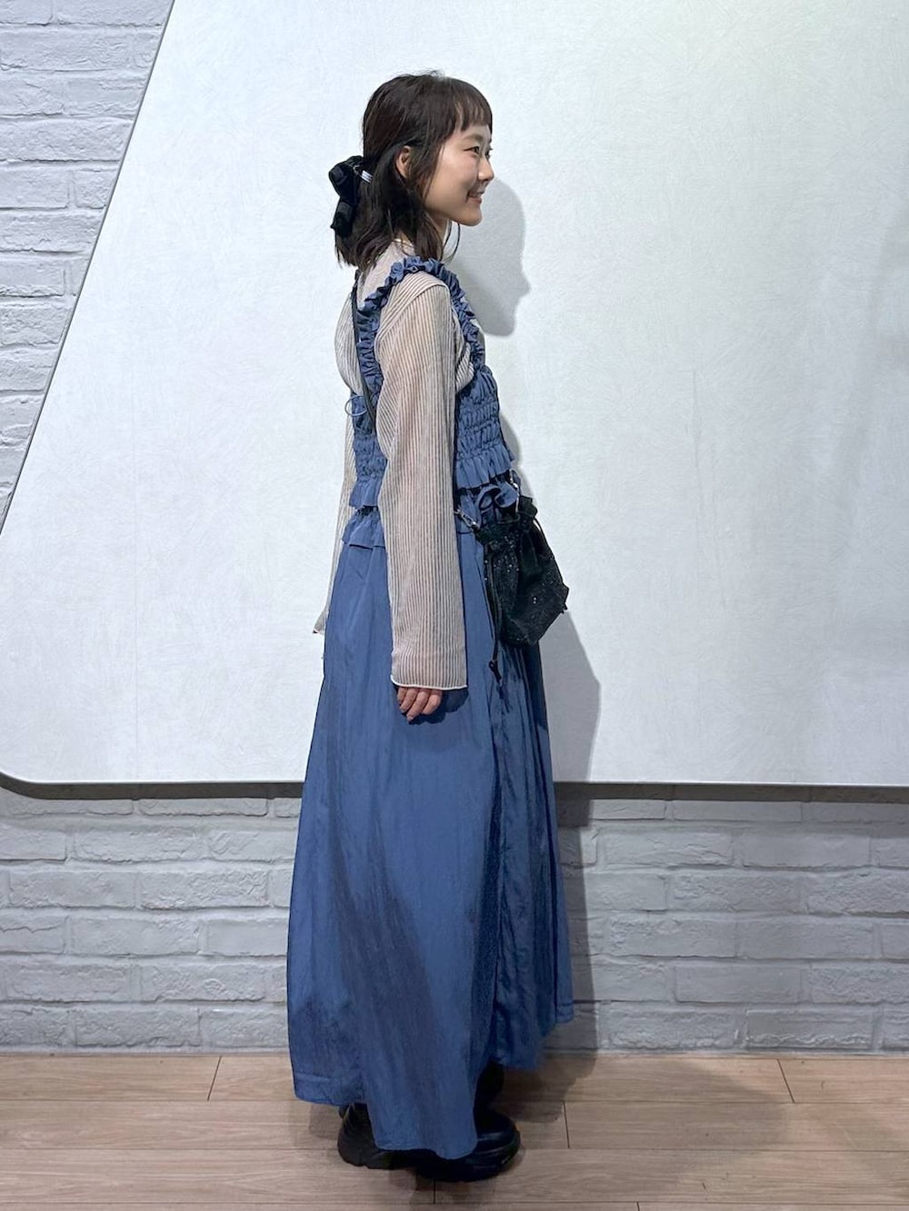 ブラック系のブーツ、ホワイト系のシャツ/ブラウス、ブラック系のキャミソールを着用したレディースの秋コーディネートの3枚目の写真