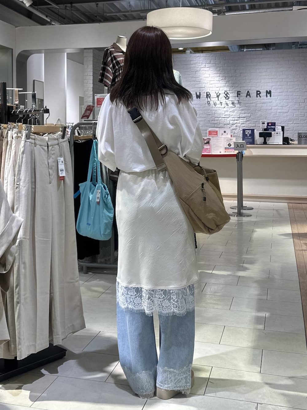 ベージュ系のショルダーバッグ、ホワイト系のTシャツ/カットソー、ブルー系のデニムパンツを着用したレディースの夏コーディネートの4枚目の写真
