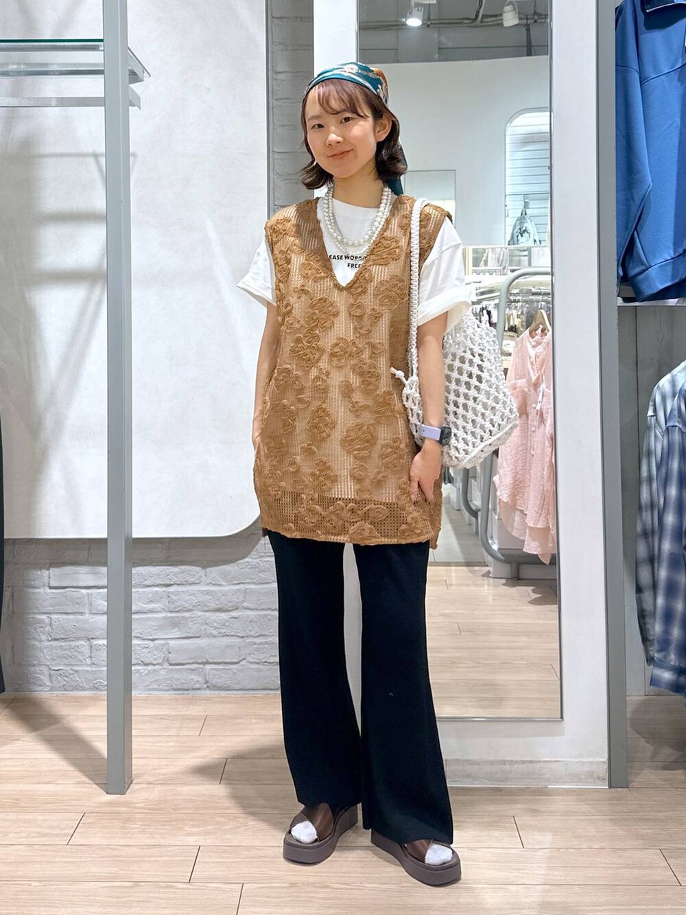 ブラウン系のサンダル、ホワイト系のトートバッグ、ホワイト系のTシャツ/カットソーを着用したレディースの夏コーディネートの4枚目の写真