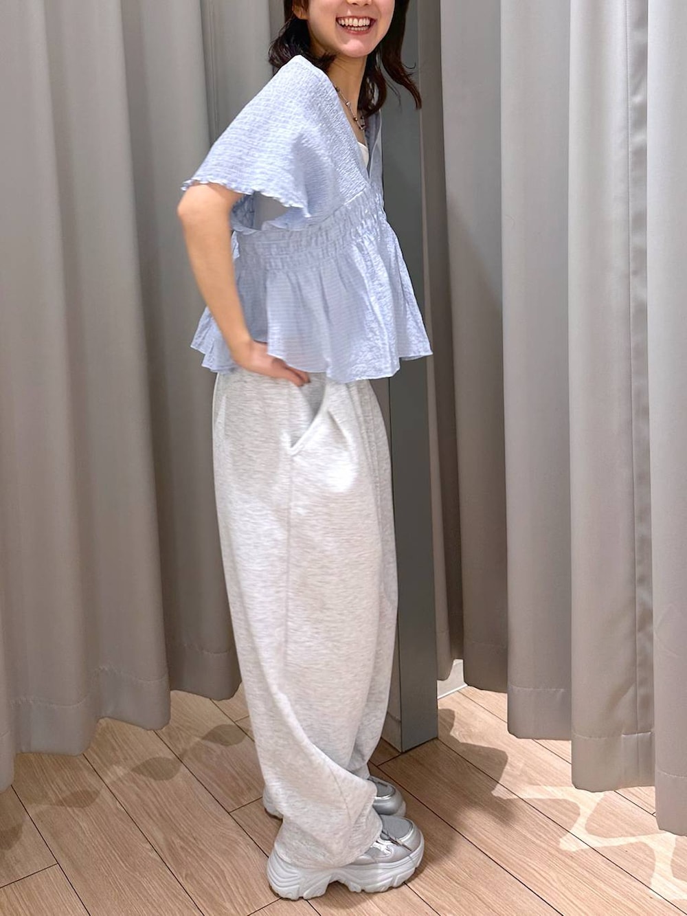 グレー系のスウェットパンツ、ホワイト系のタンクトップ、シルバー系のスニーカーを着用したレディースの春コーディネートの5枚目の写真