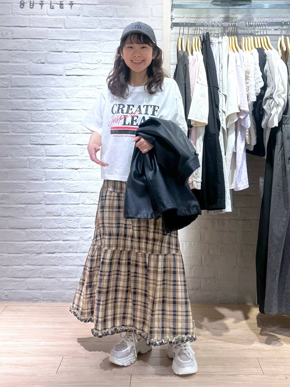 ブラック系のブルゾン、ブラック系のバックパック/リュック、ベージュ系のスニーカーを着用したレディースの春コーディネートの2枚目の写真