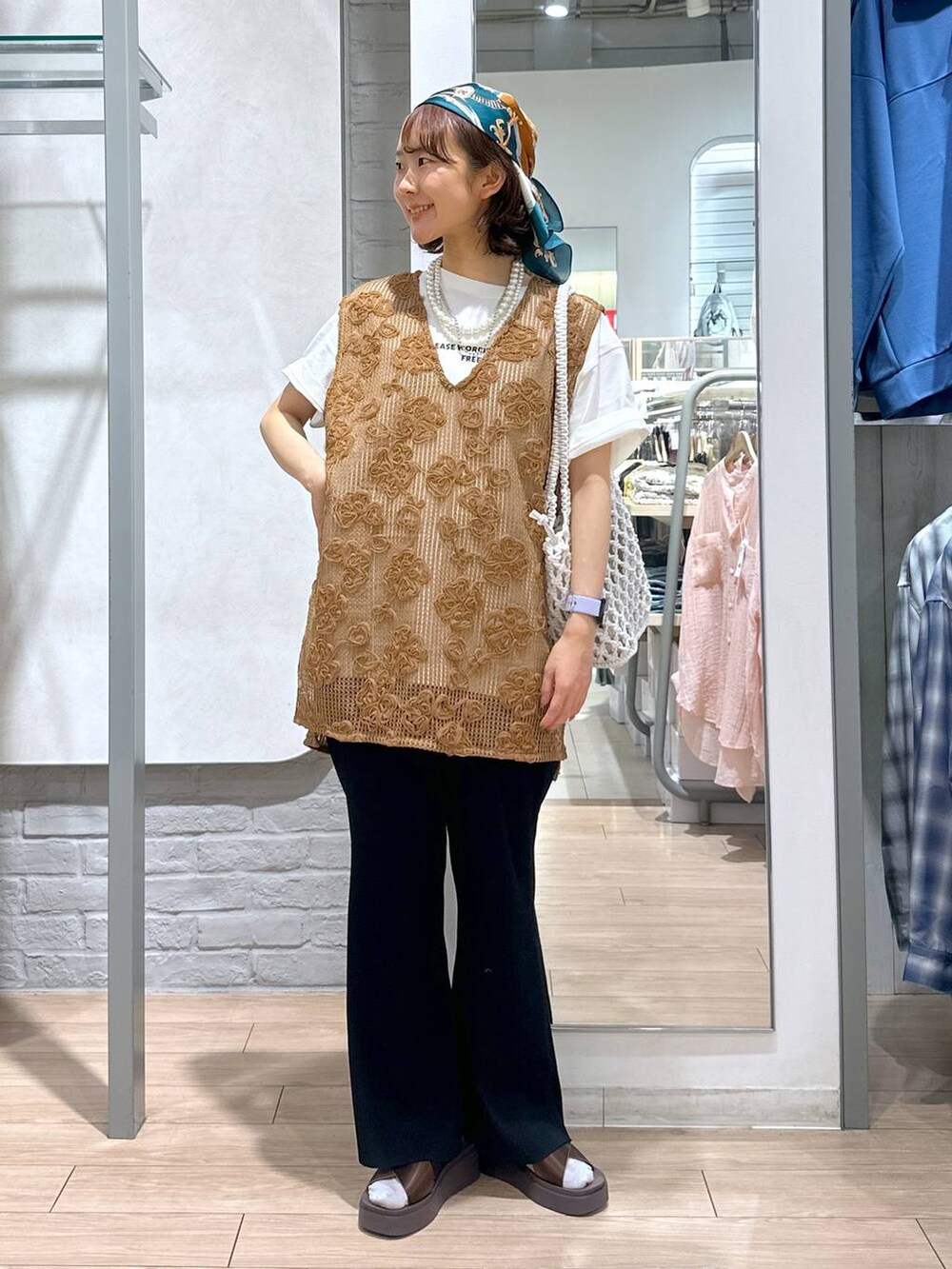 ブラウン系のサンダル、ホワイト系のトートバッグ、ホワイト系のTシャツ/カットソーを着用したレディースの夏コーディネートの3枚目の写真