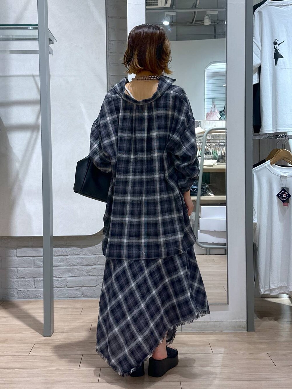 ホワイト系のTシャツ/カットソー、ブラック系のサンダル、グレー系のスカートを着用したレディースの夏コーディネートの3枚目の写真