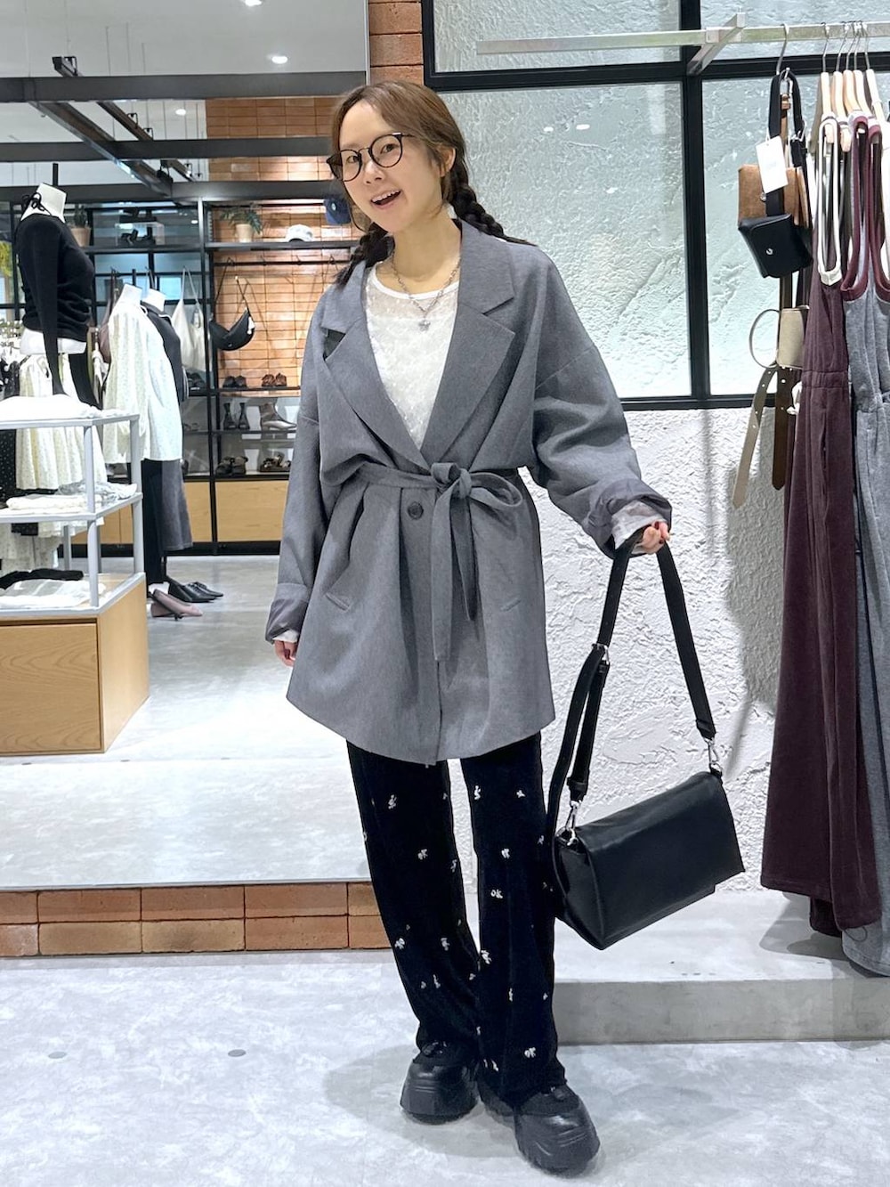 ブラック系のショルダーバッグ、ホワイト系のTシャツ/カットソー、ブラック系のスニーカーを着用したレディースの秋コーディネートの5枚目の写真