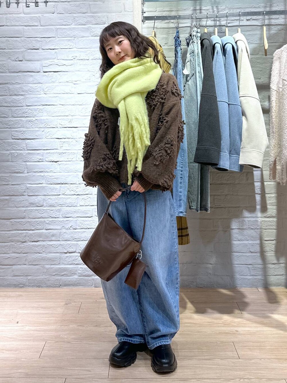 ブルー系のデニムパンツ、ブラック系のブーツ、ブラウン系のトートバッグを着用したレディースの冬コーディネートの5枚目の写真