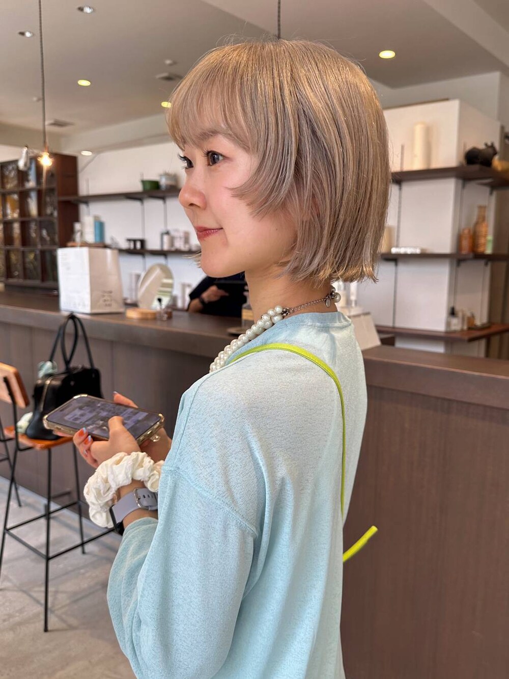 グリーン系のTシャツ/カットソー、ベージュ系のネックレスを着用したレディースの夏コーディネートの2枚目の写真