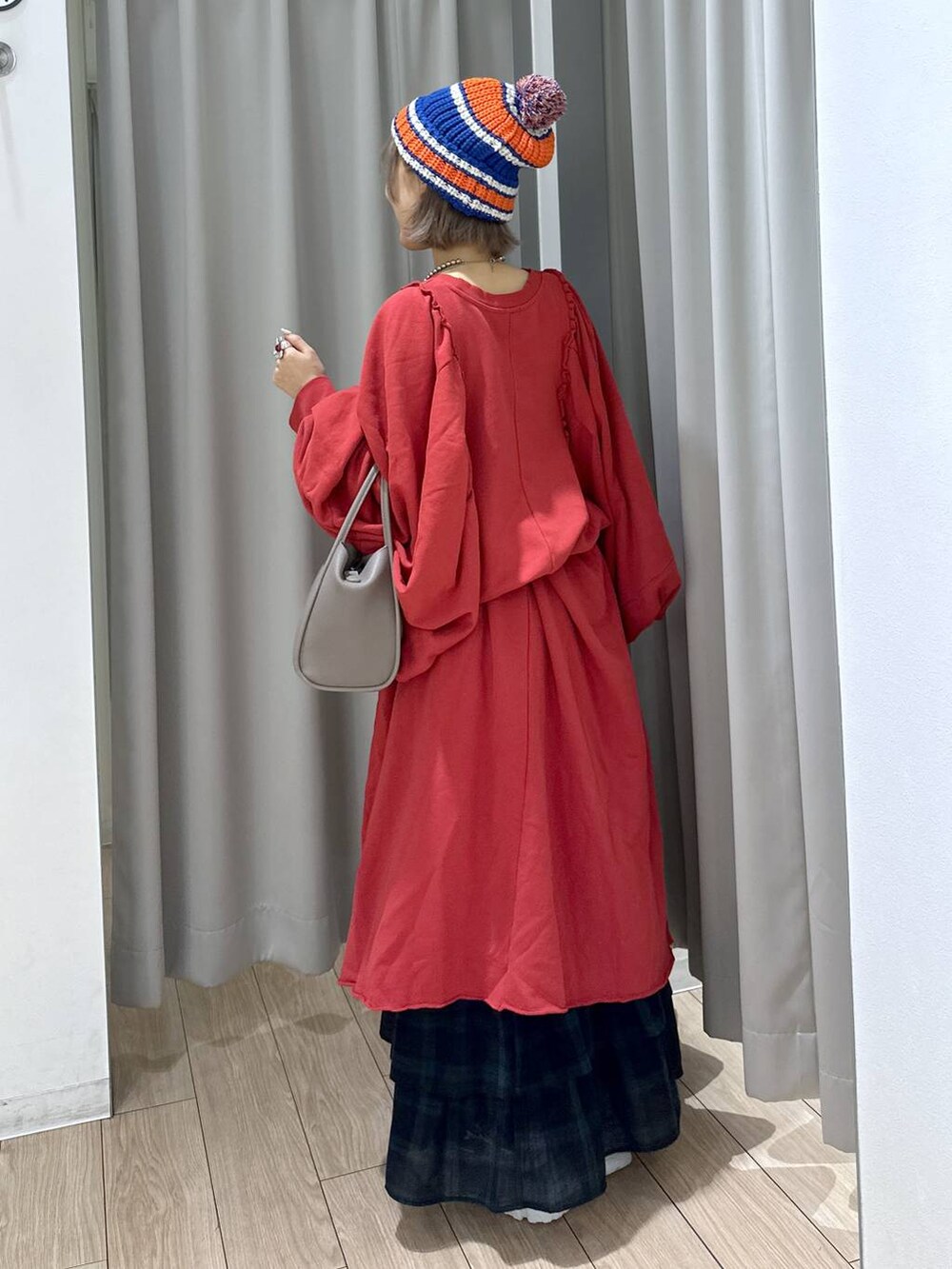 グレー系のショルダーバッグ、グリーン系のスカート、シルバー系のスニーカーを着用したレディースの秋コーディネートの3枚目の写真