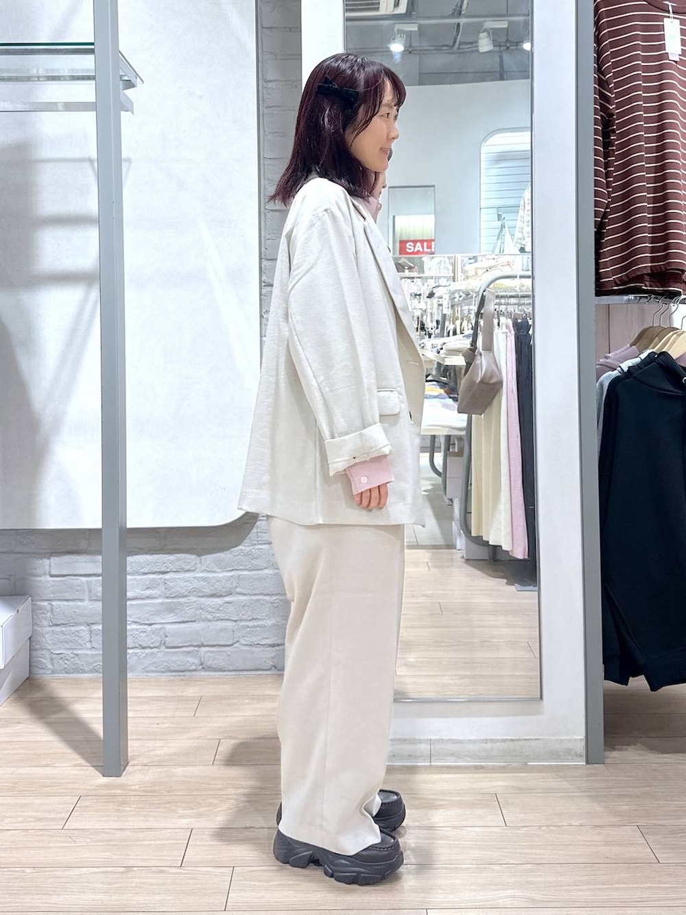 ブラック系のショルダーバッグ、ベージュ系のその他アウター、ベージュ系のその他パンツを着用したレディースの春コーディネートの4枚目の写真