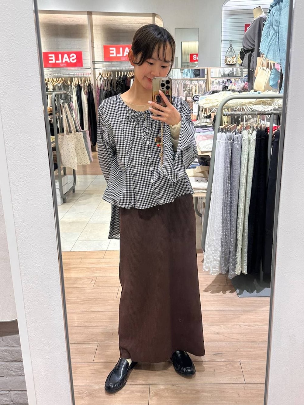 ブラウン系のスカート、ブラック系のローファー、ブラック系のシャツ/ブラウスを着用したレディースの春コーディネートの4枚目の写真