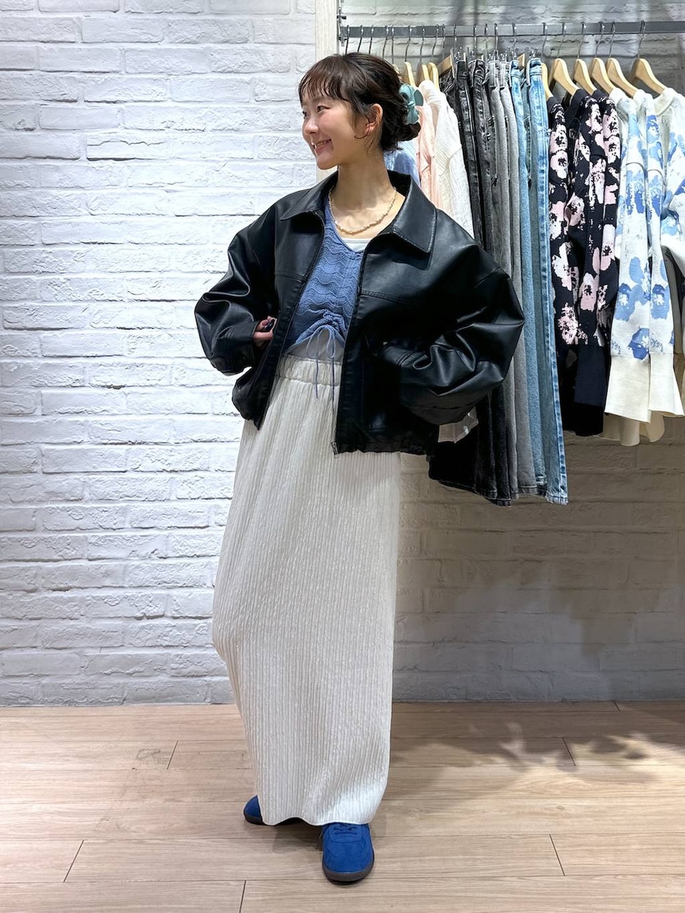 ホワイト系のTシャツ/カットソー、ホワイト系のスカート、ブルー系のスニーカーを着用したレディースの春コーディネートの2枚目の写真