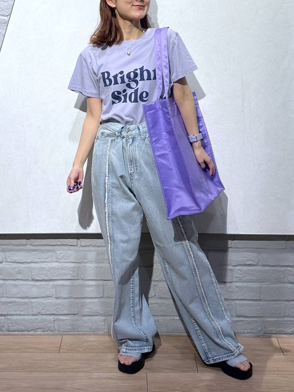 シルバー系のサンダル、パープル系のトートバッグ、ブルー系のデニムパンツを着用したレディースの夏コーディネートの4枚目の写真