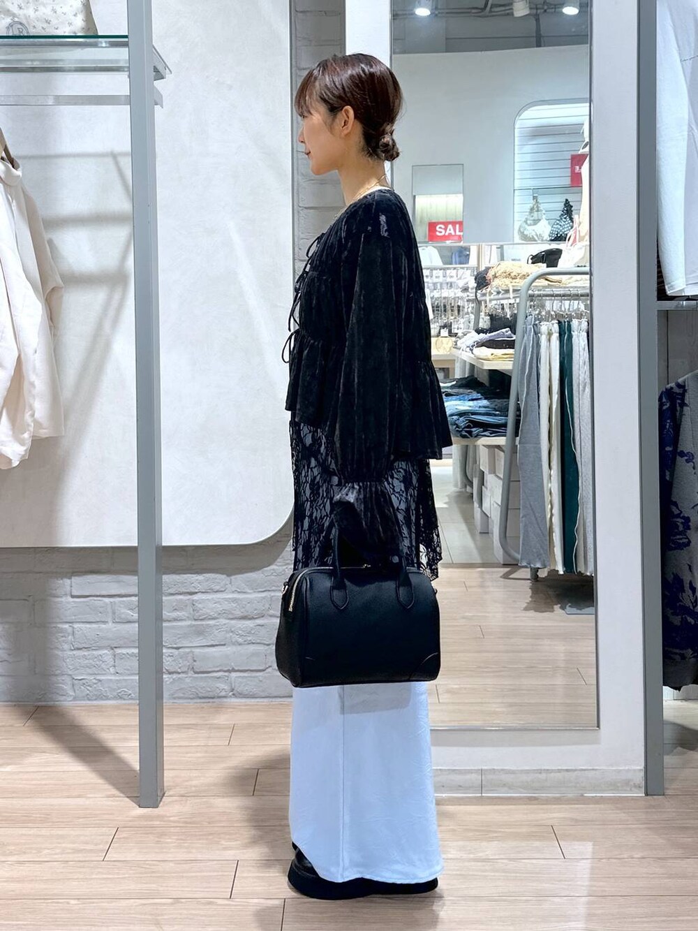 ブルー系のスカート、ブラック系のスカート、ブラック系のショルダーバッグを着用したレディースの夏コーディネートの3枚目の写真