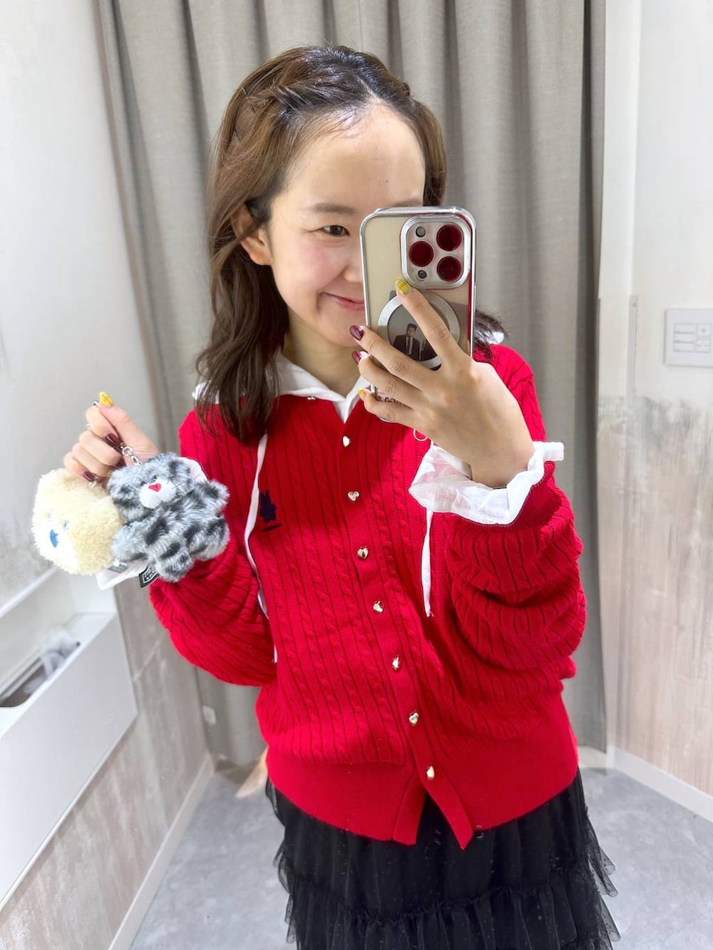 レッド系のカーディガン/ボレロ、ブラック系のスカート、ホワイト系のシャツ/ブラウスを着用したレディースの秋コーディネートの5枚目の写真