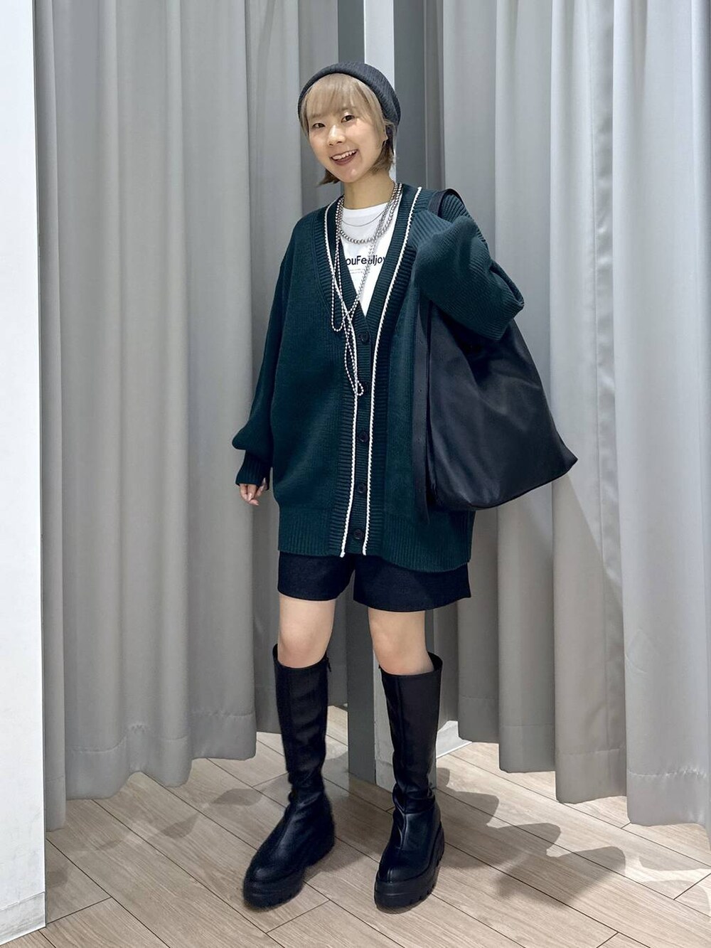 ブラック系のショルダーバッグ、グリーン系のカーディガン/ボレロ、グレー系のその他パンツを着用したレディースの秋コーディネートの4枚目の写真