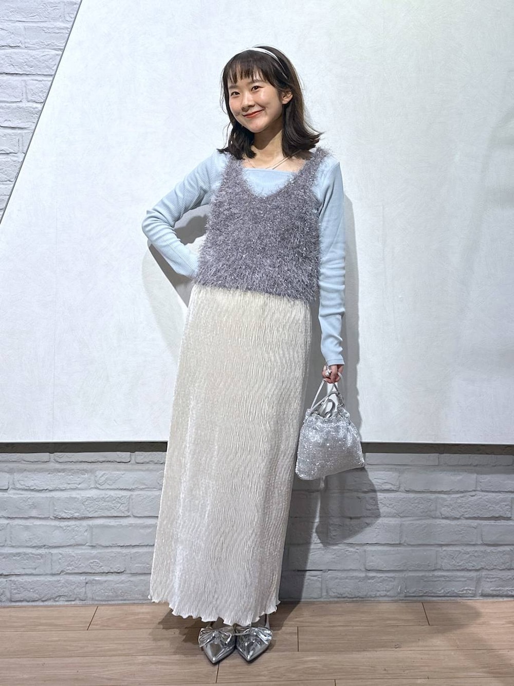 シルバー系のパンプス、グレー系のキャミソール、シルバー系のショルダーバッグを着用したレディースの秋コーディネートの4枚目の写真