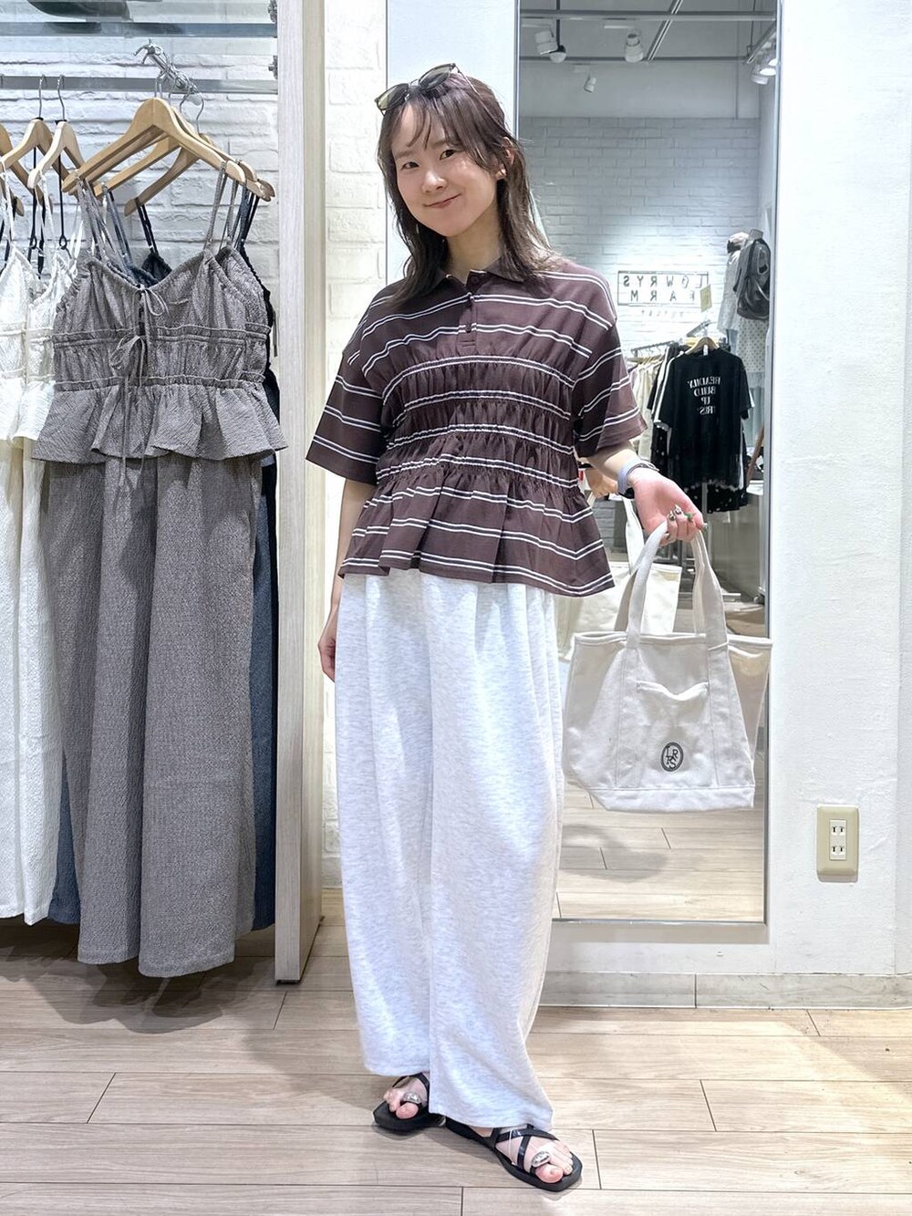 グレー系のスウェットパンツ、ホワイト系のショルダーバッグ、ブラック系のサンダルを着用したレディースの夏コーディネートの5枚目の写真